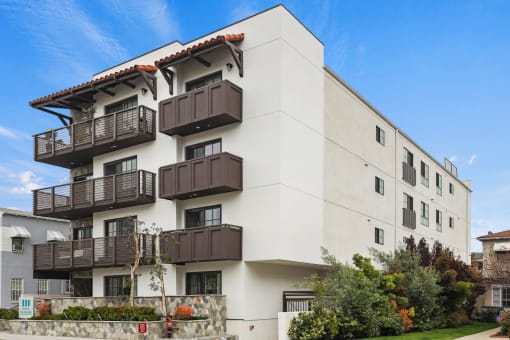 a white apartment building with brown balconies
