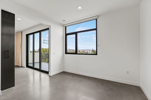 Bedroom with Large Windows, Concrete Flooring, and Recessed Lighting