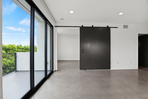 Living Room with Spacious Patio, Concrete Flooring, and Recessed Lighting