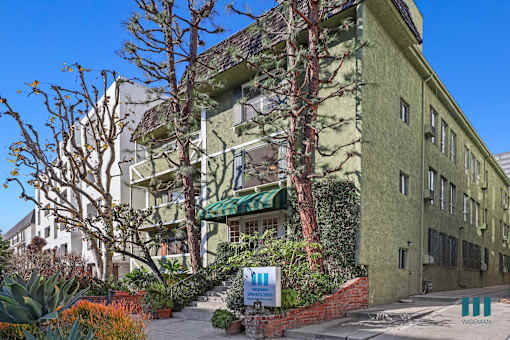 A green building with a sign that says WISEMAN in front of it.