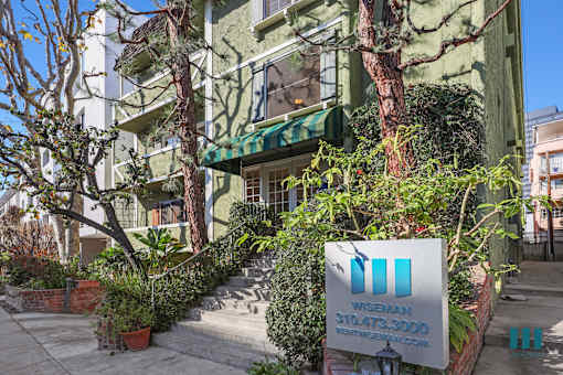 A green building with a sign in front that says "Wise 310.473.3000".