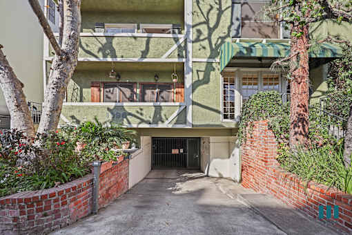 A green building with a tree in front of it.