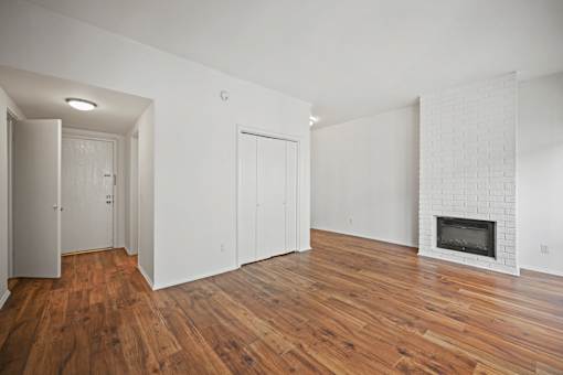 A room with a fireplace and wood floors.