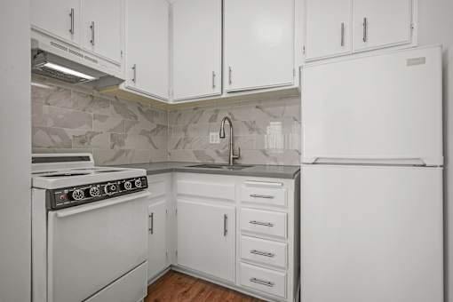 A kitchen with white appliances and cabinets.