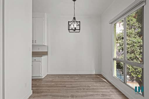 A room with a wooden floor and a hanging light fixture.