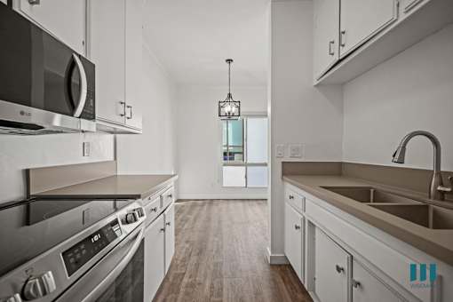 A modern kitchen with stainless steel appliances and white cabinets.