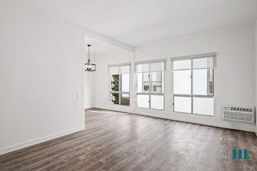 A room with a wooden floor and a large window.