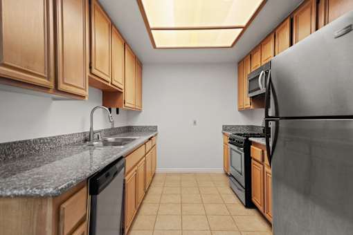 a kitchen with wood cabinets and stainless steel appliances and granite counter tops