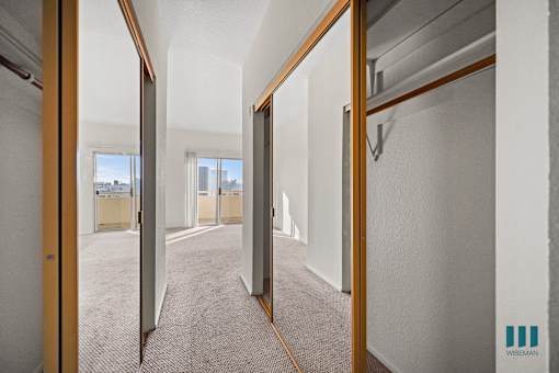 A hallway with a carpeted floor and white walls.