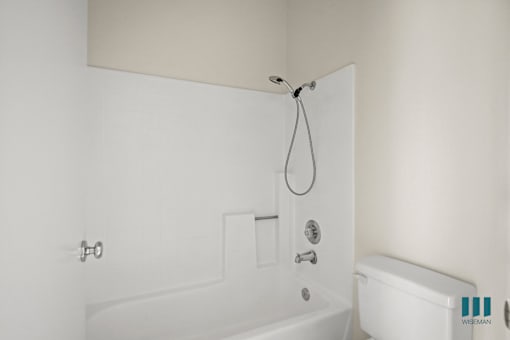 A white bathroom with a tub and toilet.