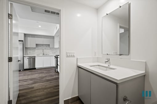 a white kitchen with a sink and a mirror
