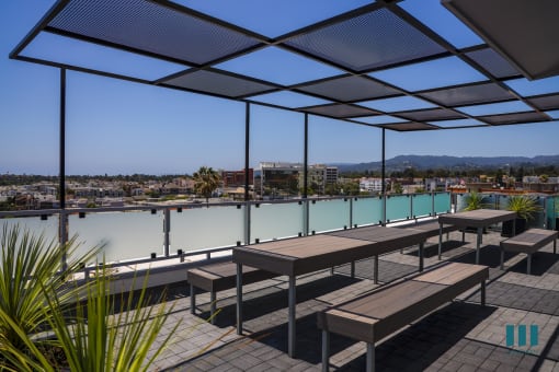 a deck with benches and tables overlooking a body of water