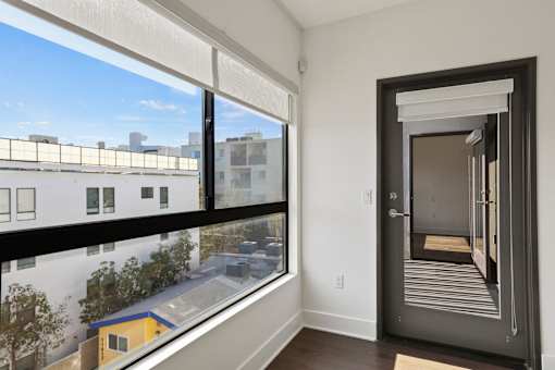 Living Room with Large Windows with Shades and Patio
