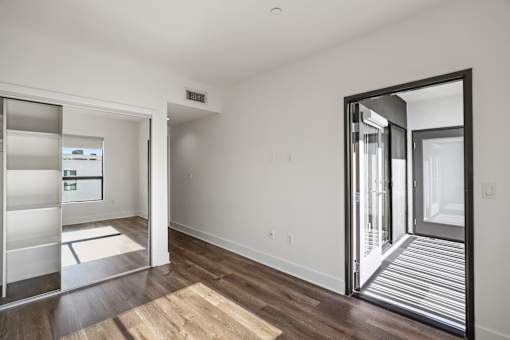 Bedroom with Mirrored Closet with Built-In Shelving and Patio