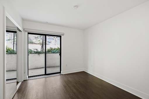 Bedroom with Mirrored Closet, Vinyl Flooring, and Patio