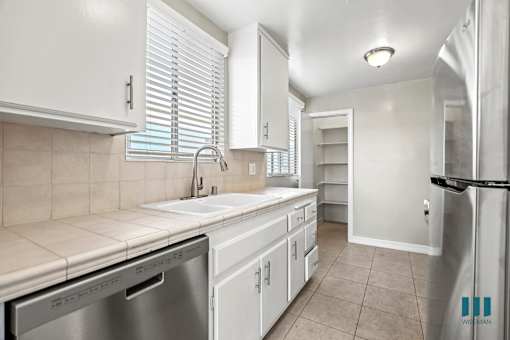Kitchen with Stainless-Steel Dishwasher, Refrigerator, and Pantry