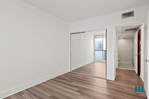 Bedroom with Mirrored Closet and Vinyl Flooring