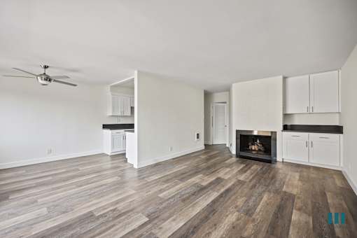 Open-Concept Dining and Living Room with Fireplace, Built-In Cabinets, and Vinyl Flooring