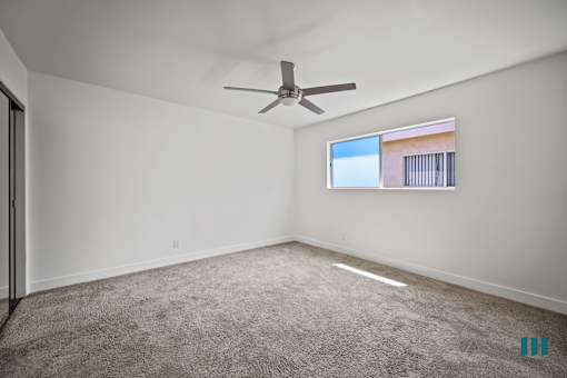 Bedroom with Mirrored Closet, Ceiling Fan, and Carpet
