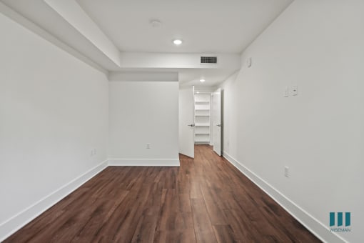 Bedroom with Walk-In Closet with Built-In Organizers, Bathroom, and Vinyl Flooring