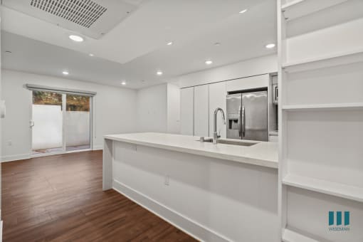 Open-Concept Kitchen, Dining, and Living Room Space with Built-In Shelving