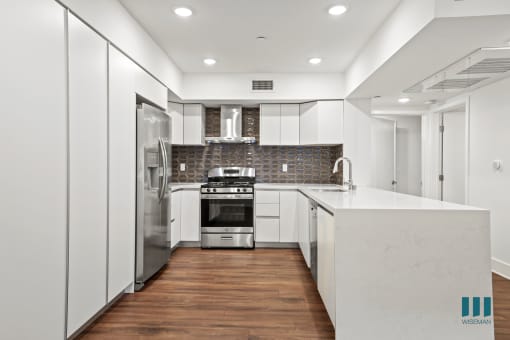 Kitchen with Stainless-Steel Refrigerator, Stove, Dishwasher, and Countertop Bar