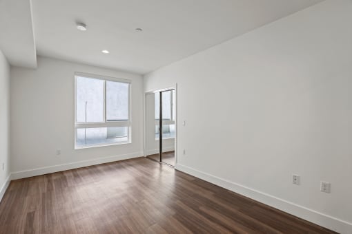 Bedroom with a Mirrored Closet, Vinyl Flooring, and Windows