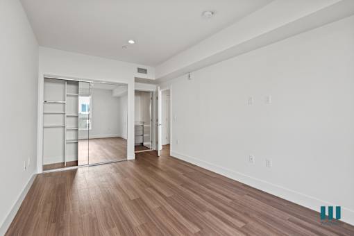 Bedroom with Mirrored Closet with Built-In Shelving, Recessed Lighting, and Vinyl Flooring