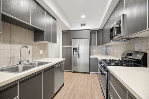 a kitchen with white countertops and stainless steel appliances