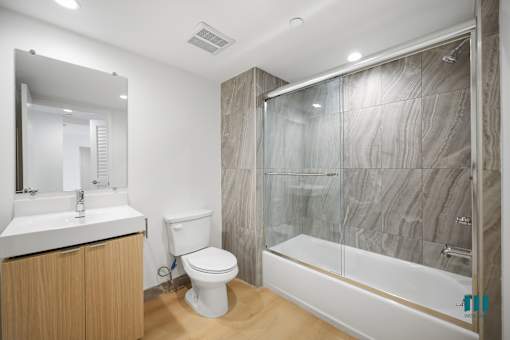 A bathroom with a toilet, sink, and shower.