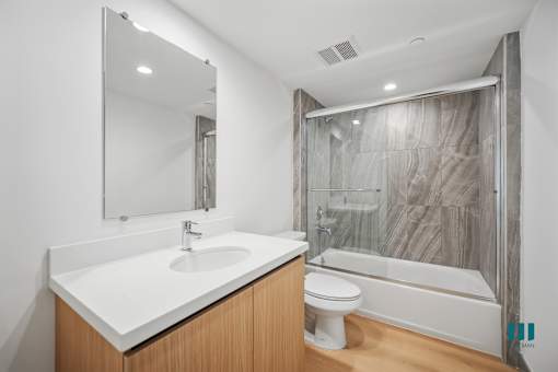 A modern bathroom with a white sink and a white toilet.