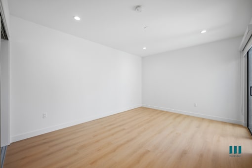 Empty room with wooden floor and white walls.