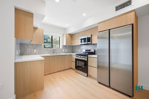 A modern kitchen with wooden cabinets and stainless steel appliances.