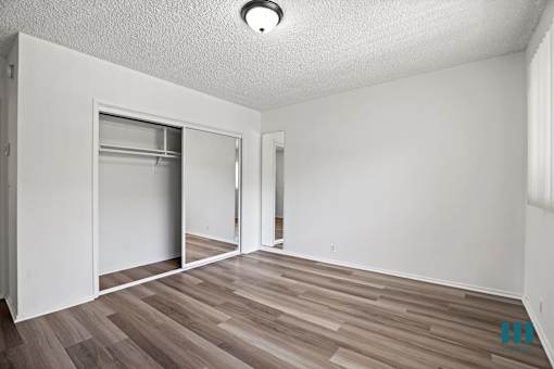 A room with a white wall and a wooden floor.