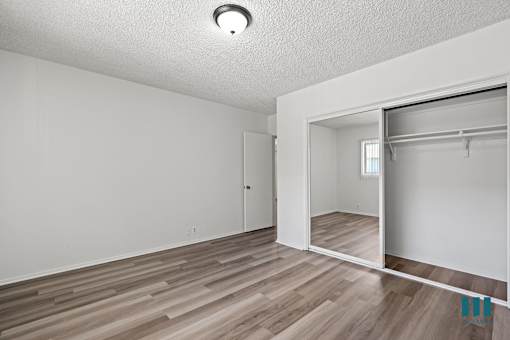 A room with a sliding door and wood flooring.