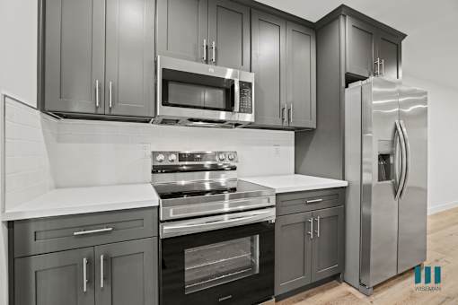 A kitchen with a stove, oven, microwave, and refrigerator.
