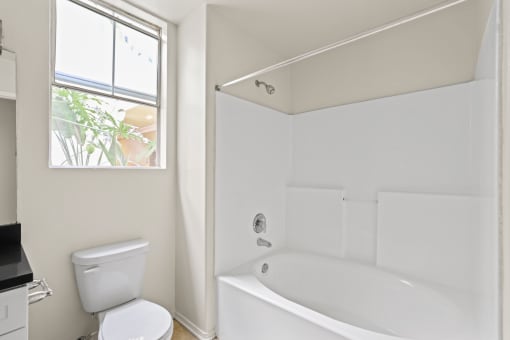 Bathroom with Window, Bathtub, and Cabinet Storage