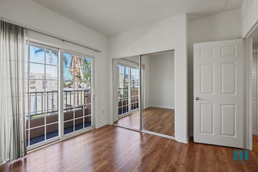 an empty living room with sliding glass doors and a balcony