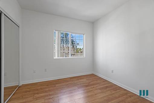 Bedroom with Mirrored Closet, Vinyl Flooring, and Windows