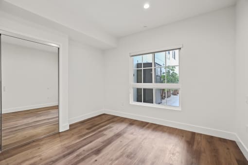 Bedroom with Mirrored Closet, Vinyl Flooring, Window, and Vinyl Flooring