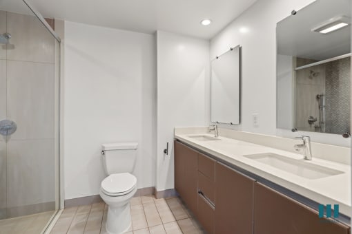 Bathroom with Walk-In Shower, Double-Sink Vanity, and Cabinet Storage