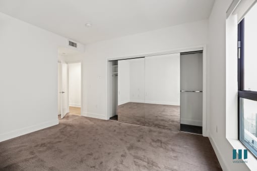 Bedroom with Mirrored Closet and Windows