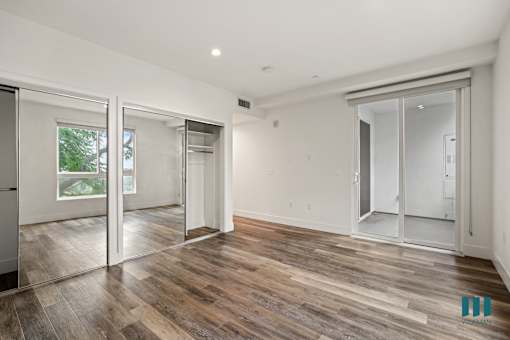 Bedroom with Mirrored Closets, Vinyl Flooring, and Patio