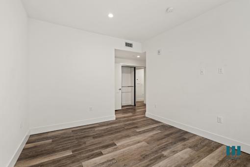 Bedroom with Vinyl Flooring and Mirrored Closets