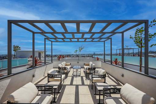 A rooftop patio with a pool and lounge chairs.