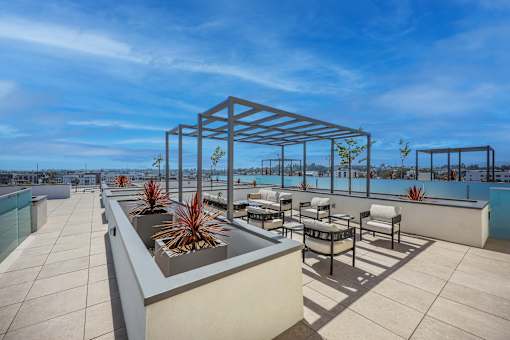 A rooftop patio with a table and chairs.