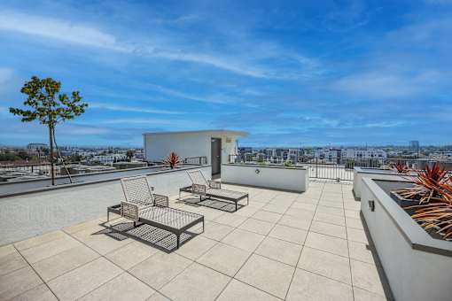 A patio with a table and chairs overlooking a cityscape.