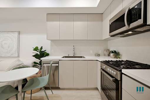 Open-Concept Kitchen with Stainless-Steel Appliances and Ample Cabinet Storage