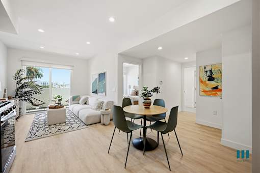 A modern living room with a dining table and chairs.