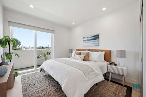 A bedroom with a large bed and a view of the outside.